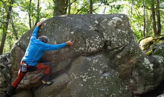 un homme escalade un rocher