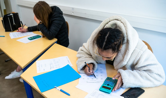 Deux jeunes assises travaillent durant un atelier de remise à niveau en mathématiques