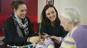 Amandine et Marjolaine accompagnent une résidente qui découvre son sac à souvenirs©DR