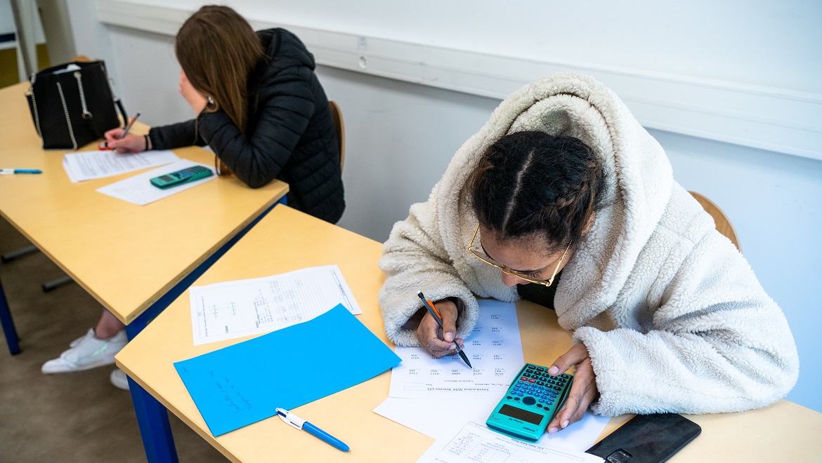 Deux jeunes assises travaillent durant un atelier de remise à niveau en mathématiques