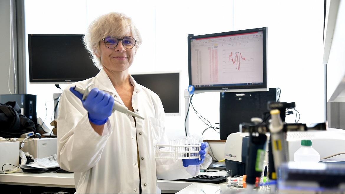 Un femme souriante travaille dans son laboratoire de recherche scientifique