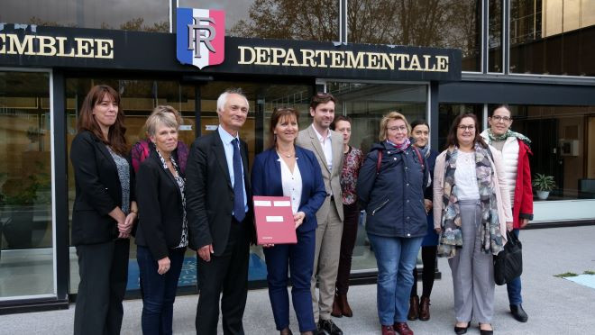 Les signataires devant l'Assemblée départementale.